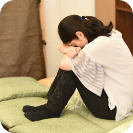 かがんで泣く女性